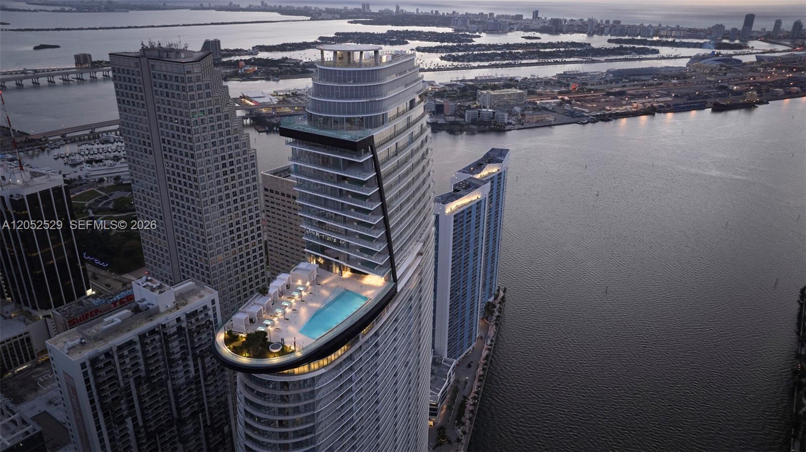 Aerial view of a high-rise building featuring a prominent cantilevered pool deck at sunset — 300 Biscayne Boulevard Way # 1705W, Miami FL 33131, MIAMI, FL