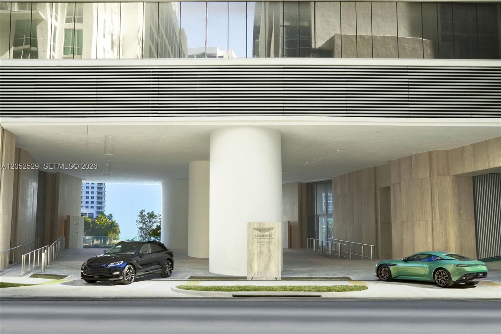This rendering shows the exterior entrance of a building with two luxury cars parked outside — 300 Biscayne Boulevard Way # 1705W, Miami FL 33131, MIAMI, FL