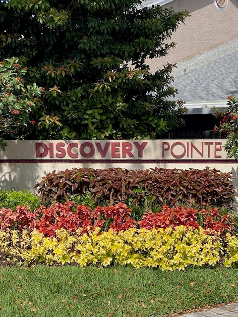 A sign reading Discovery Pointe stands in front of a landscaped garden and a building — 2217 Discovery Circle W, Deerfield Beach FL 33442, DEERFIELD BEACH, FL
