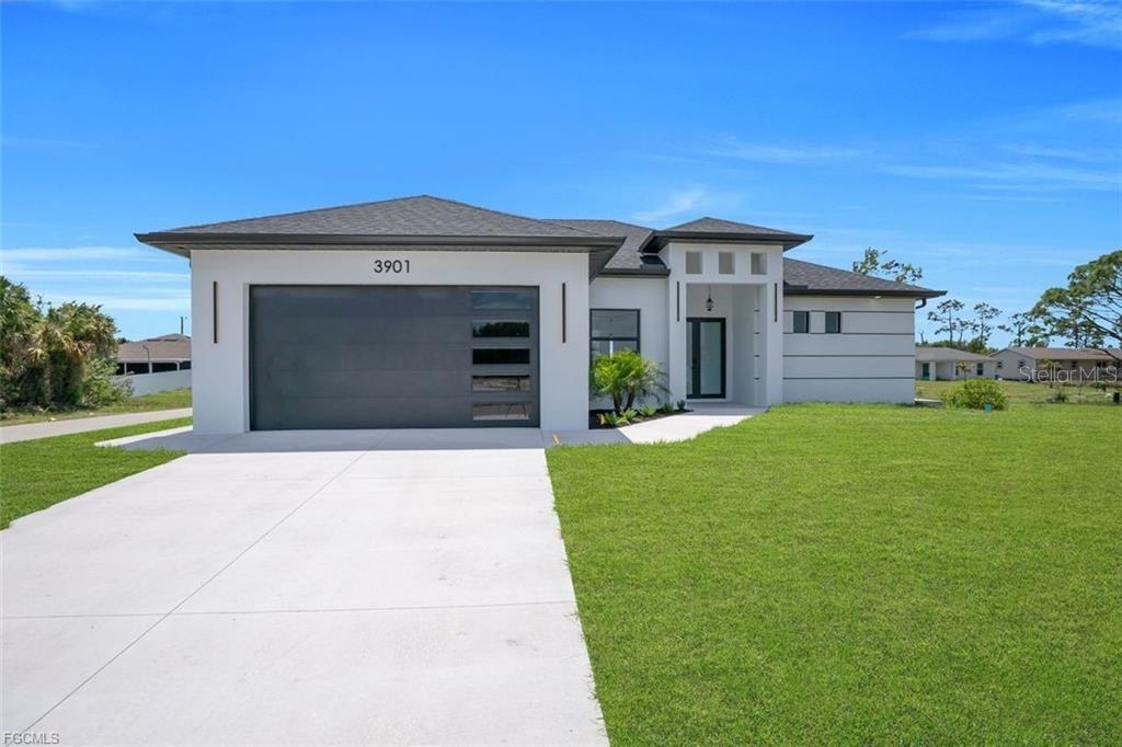 A modern single-story house with a white exterior, dark roof, and a two-car garage — 3001 43RD STREET W, LEHIGH ACRES, FL