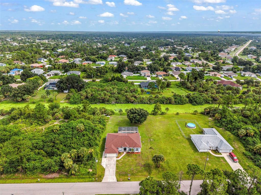 An aerial view shows two houses with pools situated on large lots near a residential neighborhood — 2142 SNOVER AVENUE, NORTH PORT, FL