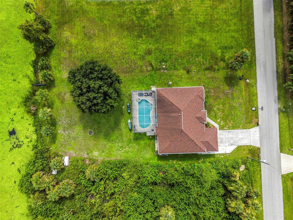 An aerial view shows a house with a pool and patio on a large grassy lot — 2142 SNOVER AVENUE, NORTH PORT, FL