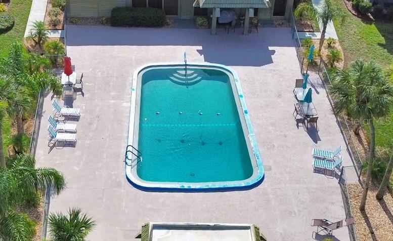 An aerial view shows a rectangular swimming pool surrounded by a concrete deck and landscaping — 600 N BOUNDARY AVENUE UNIT 114A, DELAND, FL