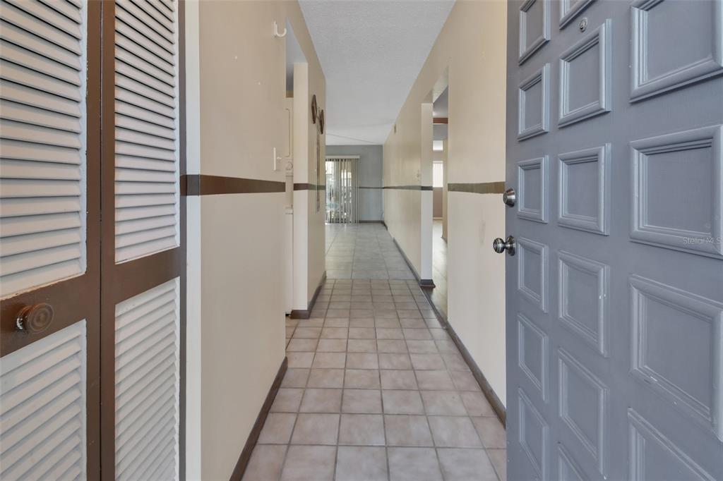 A view from an open doorway into a tiled hallway with beige walls and trim — 600 N BOUNDARY AVENUE UNIT 114A, DELAND, FL