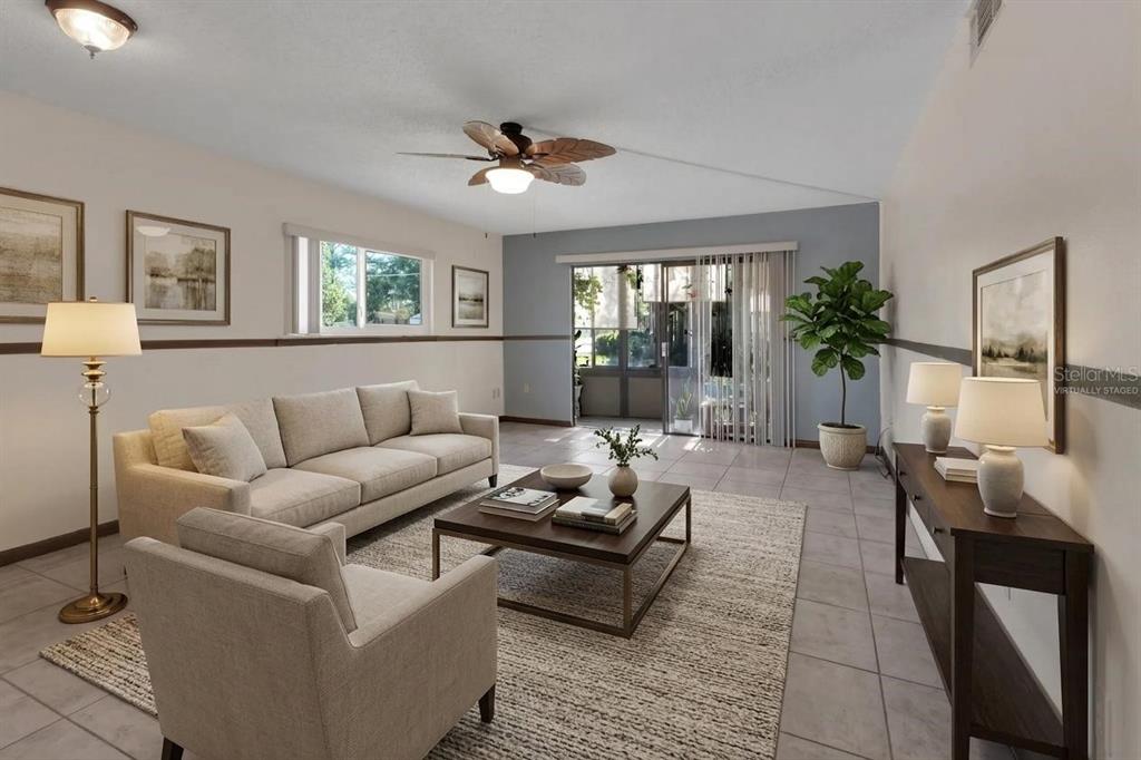 A living room with tile floors, a beige sofa, a coffee table, and a ceiling fan — 600 N BOUNDARY AVENUE UNIT 114A, DELAND, FL