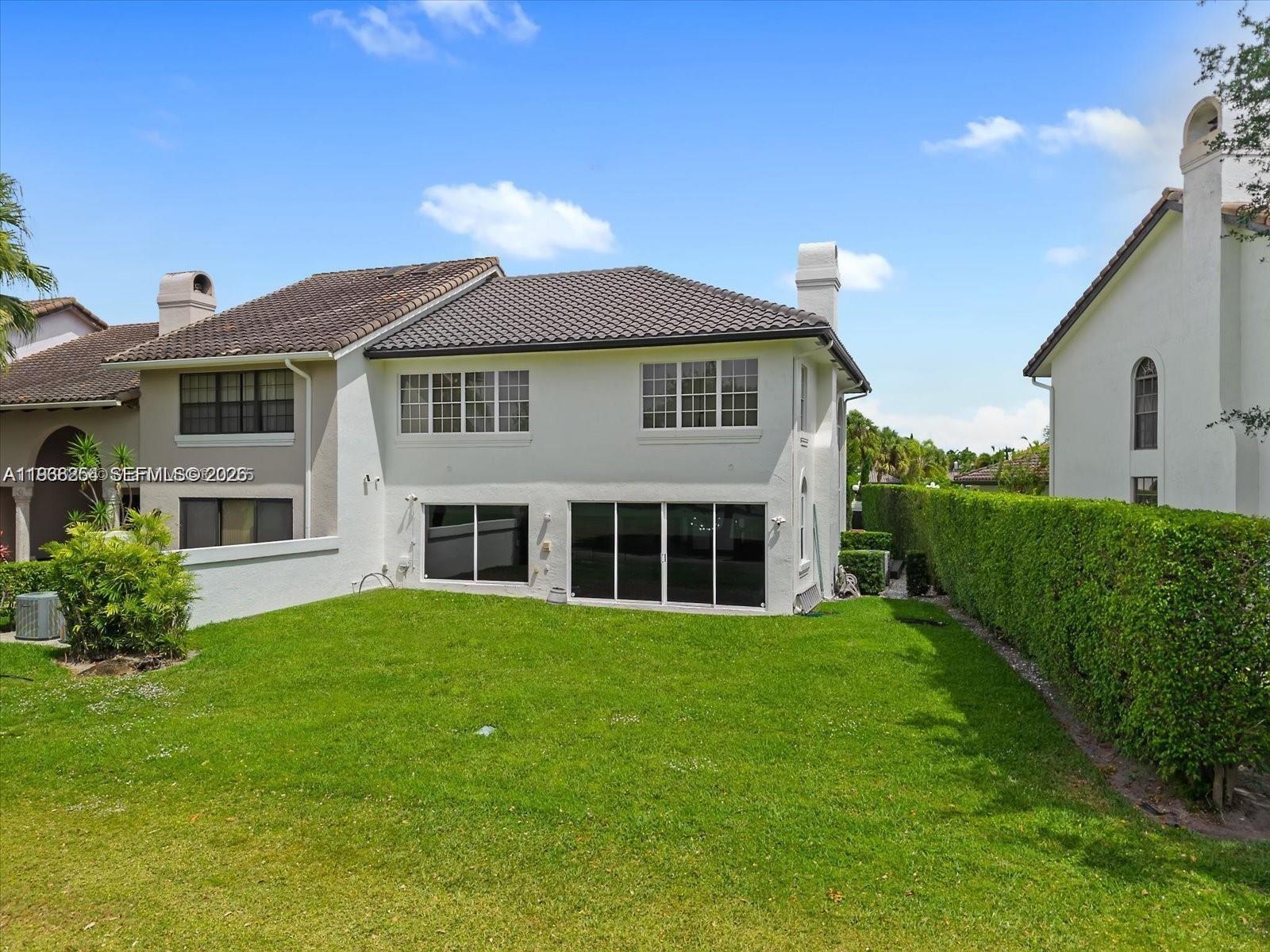 A two-story house with a tiled roof, white stucco walls, and a grassy backyard — 22818 El Dorado Dr, Boca Raton FL 33433, BOCA RATON, FL