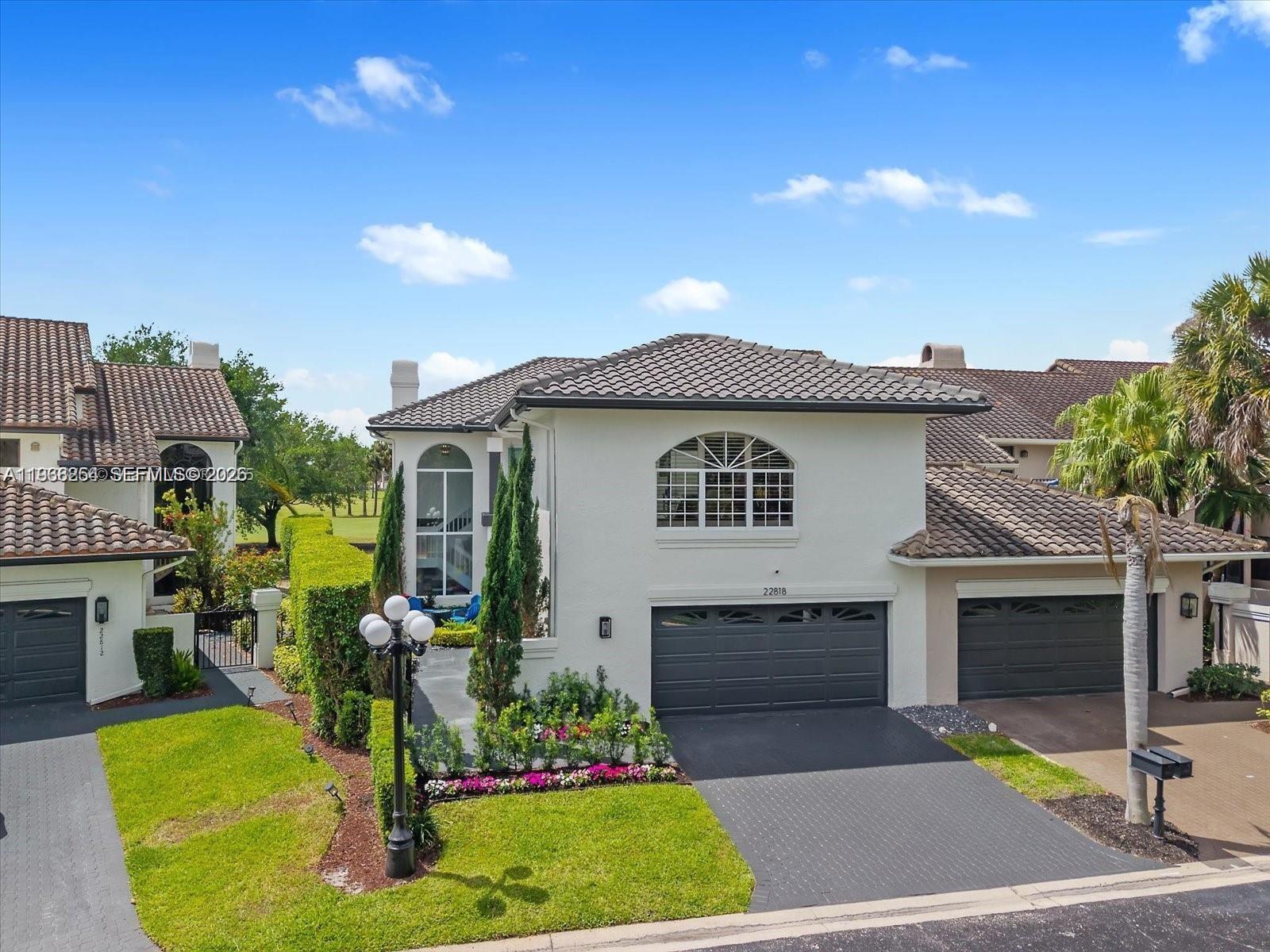 A two-story house with a dark tiled roof, gray garage doors, and a landscaped front yard — 22818 El Dorado Dr, Boca Raton FL 33433, BOCA RATON, FL