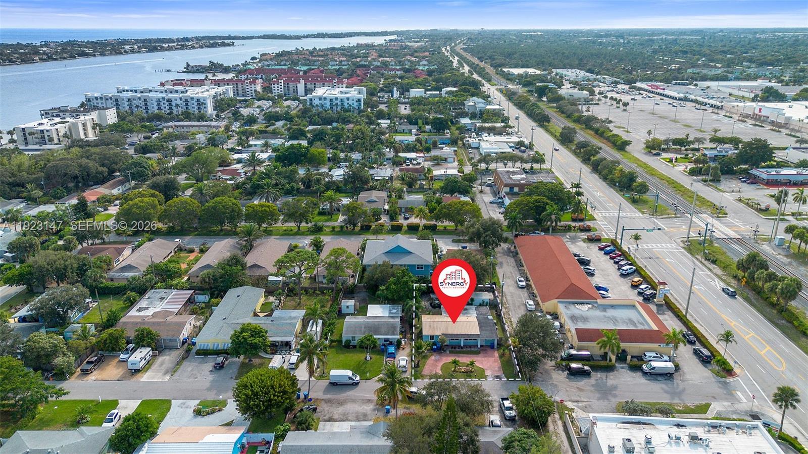 An aerial view shows a single-story house with a red-roofed commercial building nearby — 112 Milton St, Lantana FL 33462, LANTANA, FL
