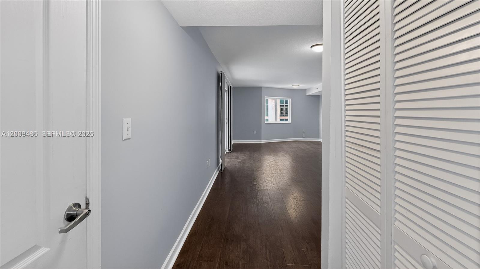 A hallway with light blue walls and dark wood flooring leads into an open room — 280 SW 20th Rd # 904, Miami FL 33129, MIAMI, FL