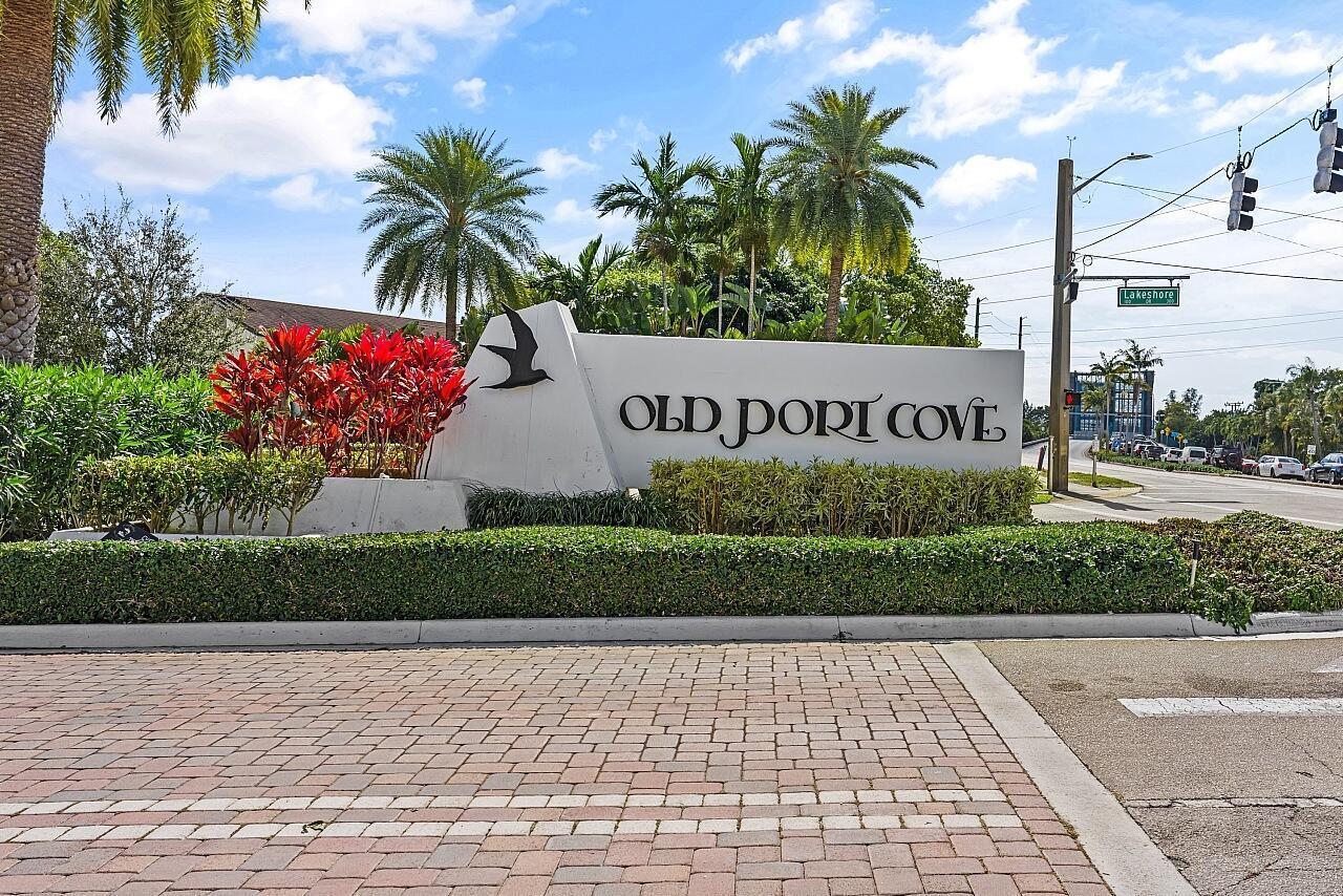 A white monument sign for Old Port Cove stands near a road with palm trees — 100 Lakeshore Drive # 252, North Palm Beach FL 33408, NORTH PALM BEACH, FL