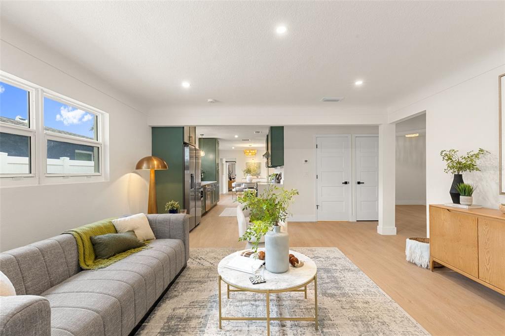A living room with a gray sofa, marble coffee table, and light wood flooring — 7042 DARTMOUTH AVENUE N, ST PETERSBURG, FL