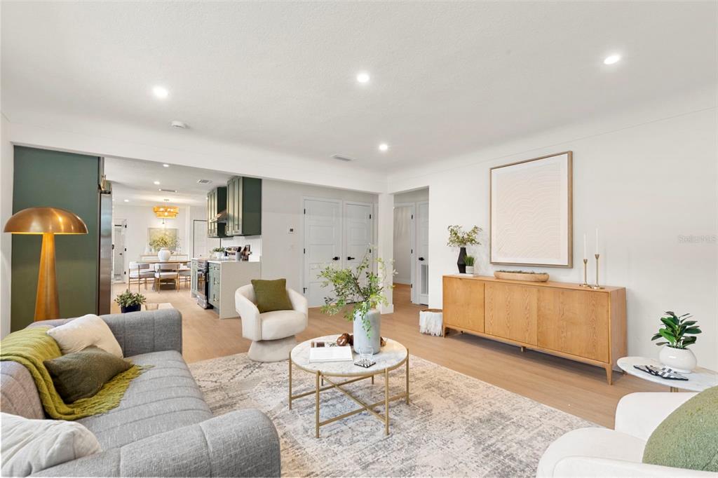 A living room features a grey sofa, a marble coffee table, and a wooden sideboard — 7042 DARTMOUTH AVENUE N, ST PETERSBURG, FL