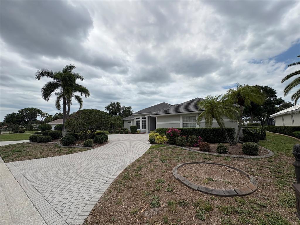 A single-story house with a paved driveway, palm trees, and a landscaped front yard — 2181 CALUSA LAKES BOULEVARD, NOKOMIS, FL