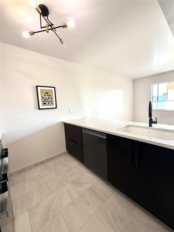 A kitchen features dark cabinets, a white countertop with an integrated sink, and tile flooring — 2525 W BAY DRIVE UNIT C34, LARGO, FL
