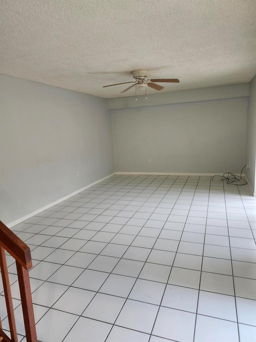 An empty room features light gray walls, white tiled flooring, and a ceiling fan — 3209 32nd Way, West Palm Beach FL 33407, WEST PALM BEACH, FL