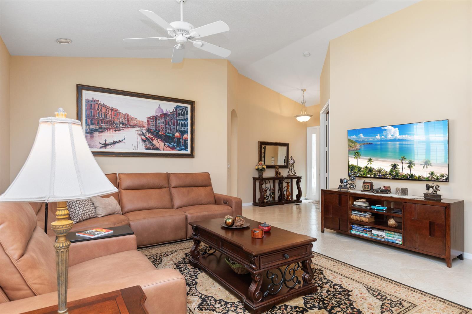 A living room features a leather sectional, a wooden coffee table, and a wall-mounted television — 6698 Vía Roma, Delray Beach FL 33446, DELRAY BEACH, FL
