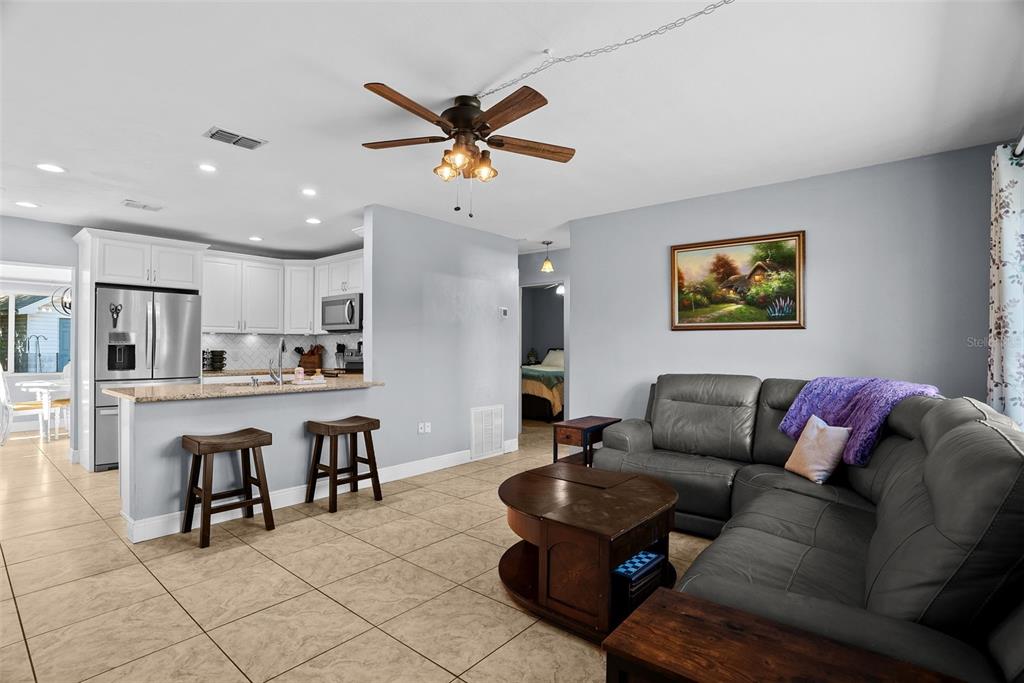A living room with tile floors and a kitchen with a breakfast bar and stools — 4817 DRIFT TIDE DRIVE, NEW PORT RICHEY, FL