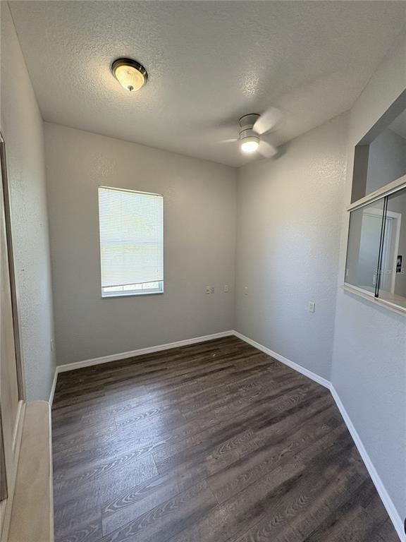 An empty room with gray walls, wood-look flooring, a ceiling fan, and a window — 1701 NE 42ND AVENUE UNIT 403, OCALA, FL