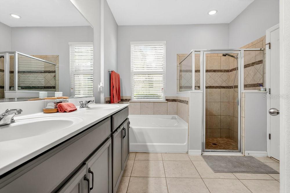 A bathroom features a double vanity, a soaking tub, and a separate glass-enclosed shower — 632 MEADOW SAGE DRIVE, DELAND, FL
