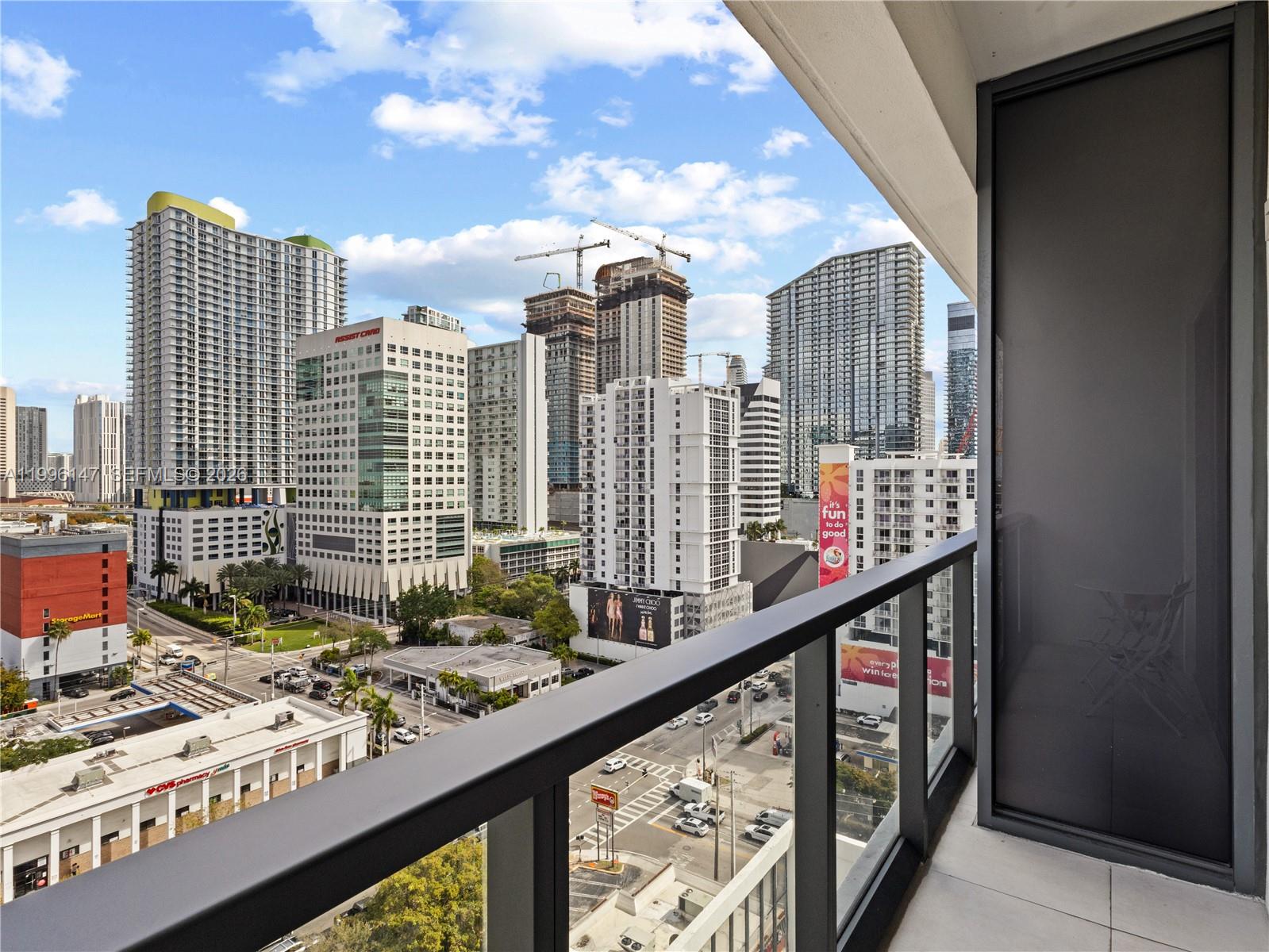 A balcony overlooks a dense urban cityscape with multiple high-rise buildings and street traffic — 239 SW 9th St # 1403, Miami FL 33130, MIAMI, FL