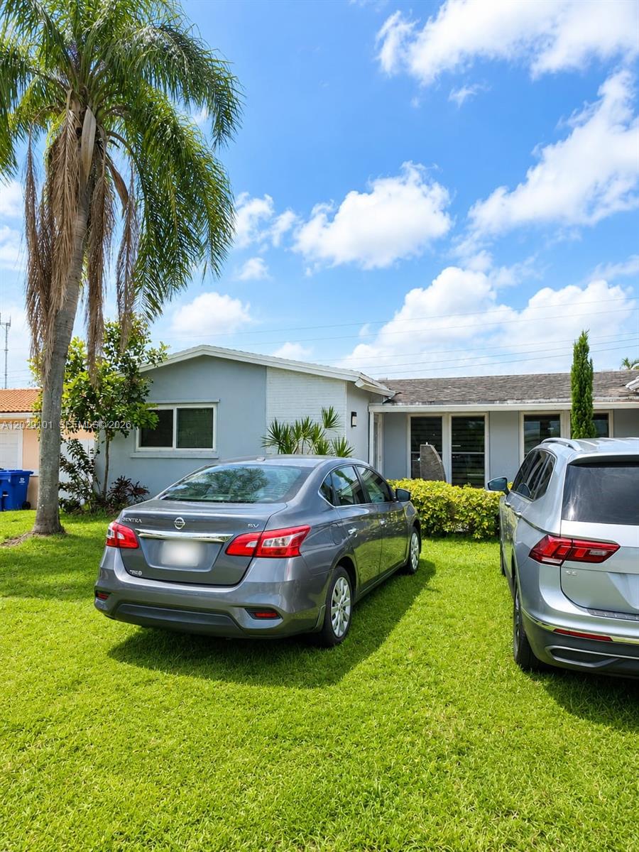 A gray Nissan Sentra and a silver SUV are parked on the lawn of a house — 7250 Dilido Blvd, Miramar FL 33023, MIRAMAR, FL