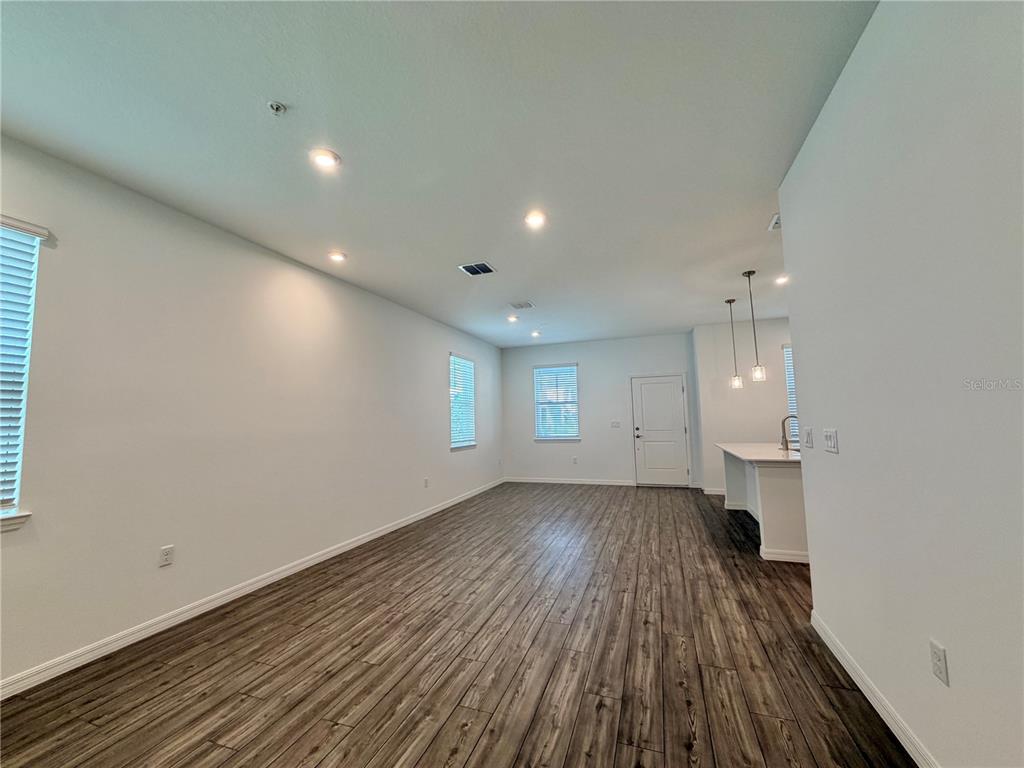 An open-concept living area features wood-look flooring, recessed lighting, and a kitchen island — 449 BELMOND DRIVE, DEBARY, FL