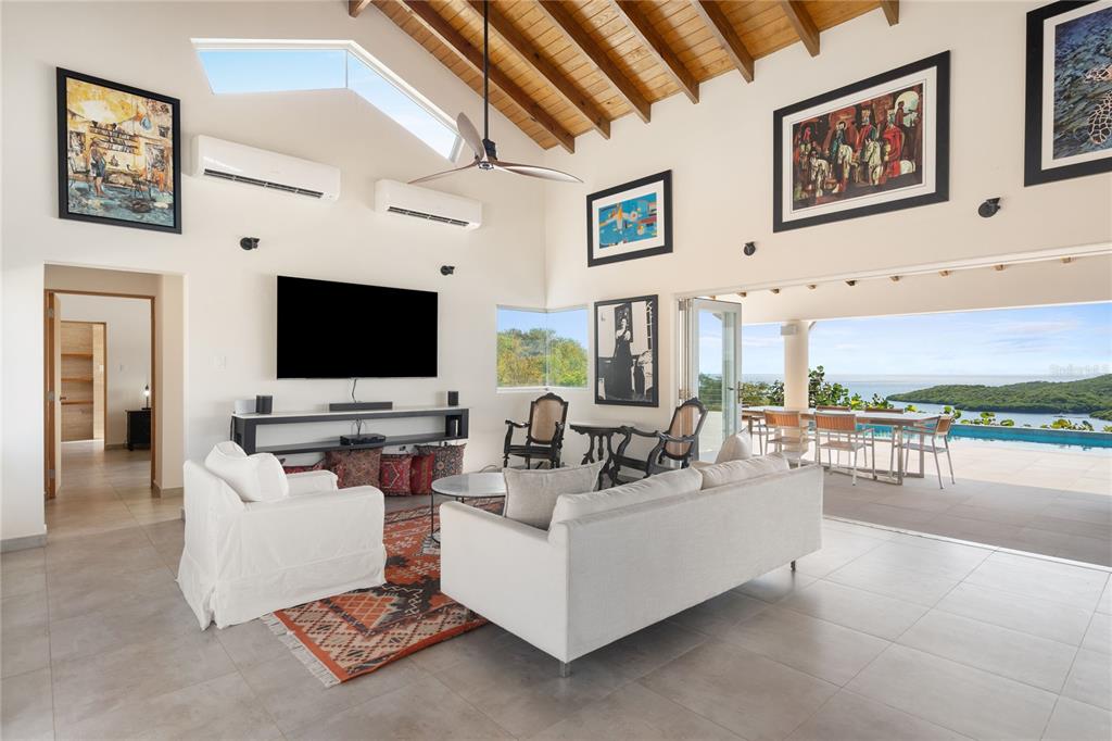 A bright living room features a vaulted wood ceiling, white furniture, and an open-air patio — 11 BARRIO FRAILES, CULEBRA, PR