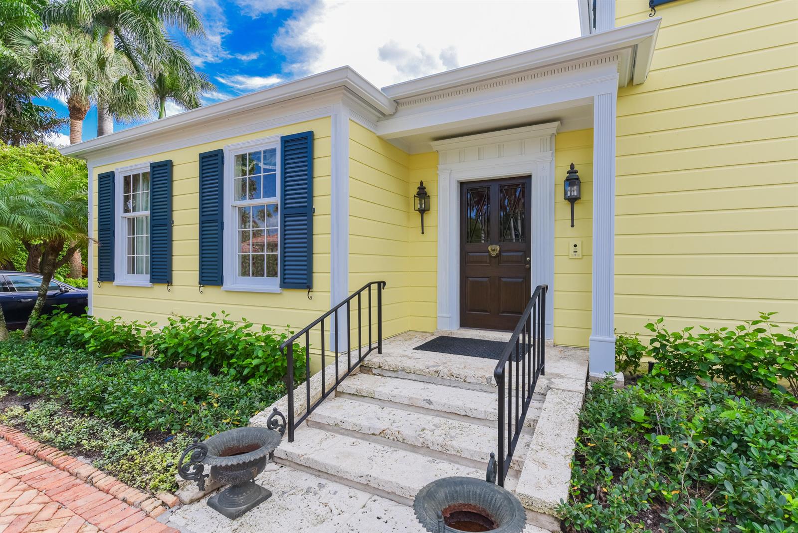 A yellow house exterior features a dark brown front door, blue shutters, and stone steps — 250 Algoma Road, Palm Beach FL 33480, PALM BEACH, FL