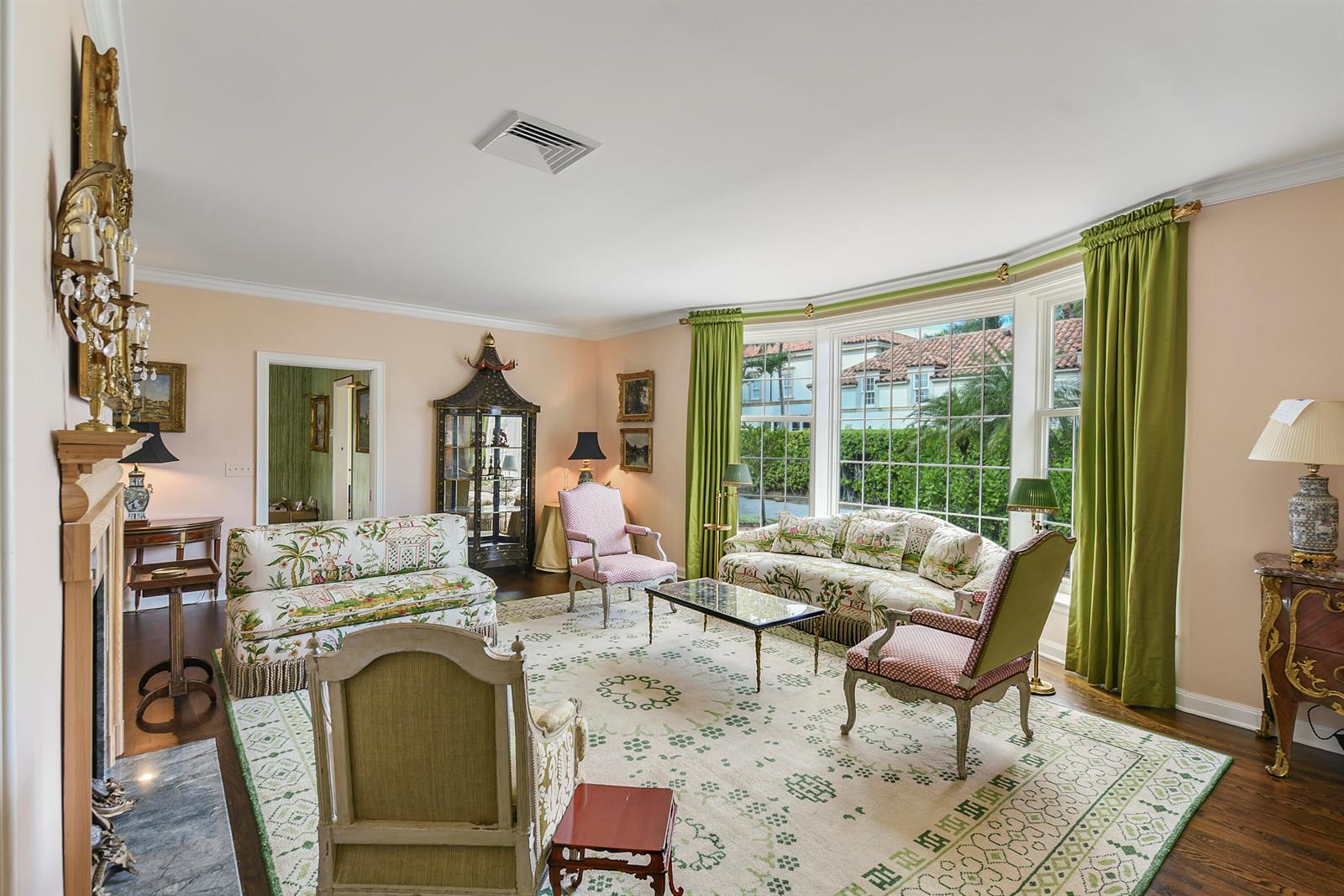 A formal living room features a fireplace, patterned furniture, green curtains, and a large rug — 250 Algoma Road, Palm Beach FL 33480, PALM BEACH, FL