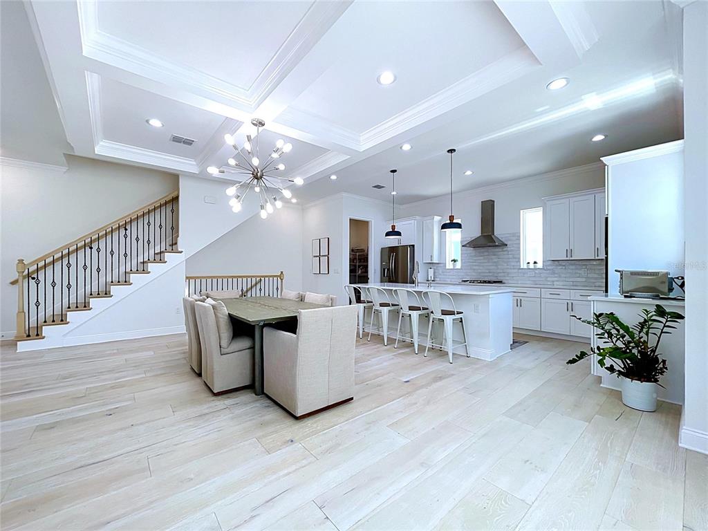 A modern open-concept kitchen and dining area features light wood floors and a coffered ceiling — 3702 W ROLAND STREET UNIT 3, TAMPA, FL