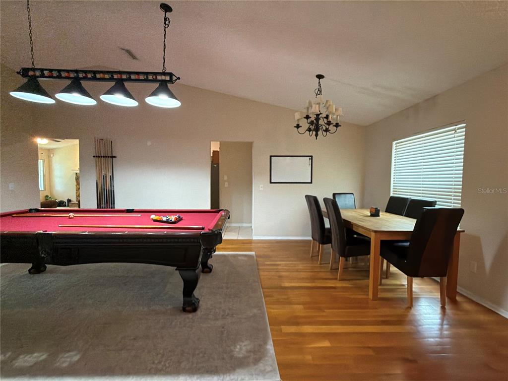 A living room with a stone fireplace, brown reclining sofas, and an open kitchen — 503 RAPID FALLS DR, BRANDON, FL