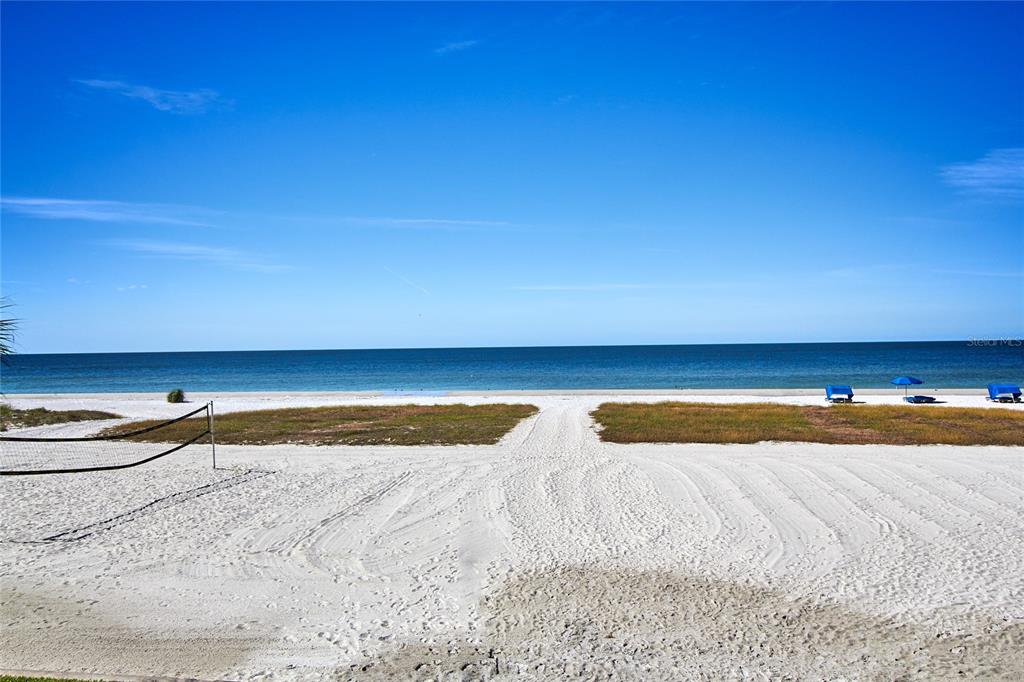 A sandy beach path leads toward the ocean with a volleyball net on the left — 18400 GULF BOULEVARD UNIT 1206, INDIAN SHORES, FL