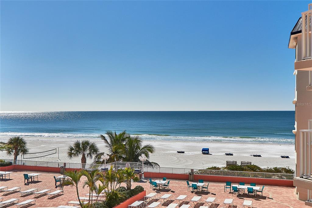 An elevated view of a beachside patio with lounge chairs overlooking the ocean — 18400 GULF BOULEVARD UNIT 1206, INDIAN SHORES, FL