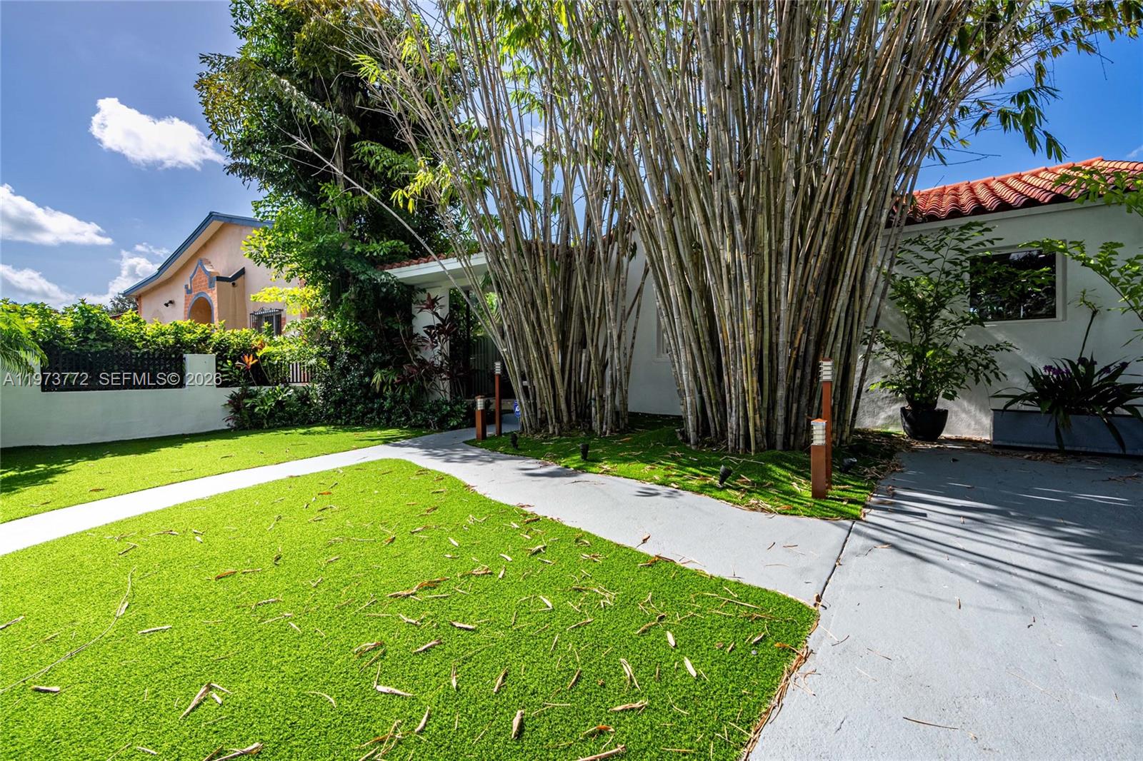 A paved walkway leads to a house entrance framed by a large cluster of bamboo — 1360 SW 16th St, Miami FL 33145, MIAMI, FL