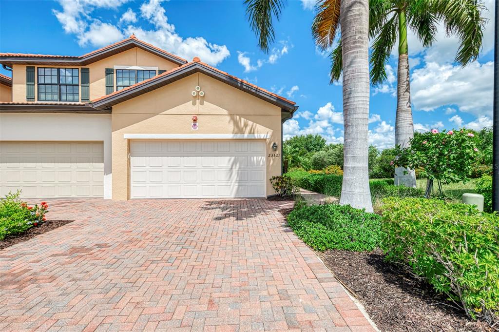 A beige two-story house with a brick paver driveway and a two-car garage — 23321 AWABUKI DRIVE UNIT 8-102, VENICE, FL