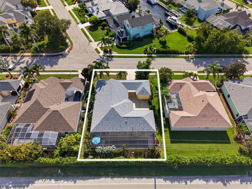An aerial view shows a residential house with a screened-in pool and gray roof — 171 AMERICAS CUP BOULEVARD, BRADENTON, FL