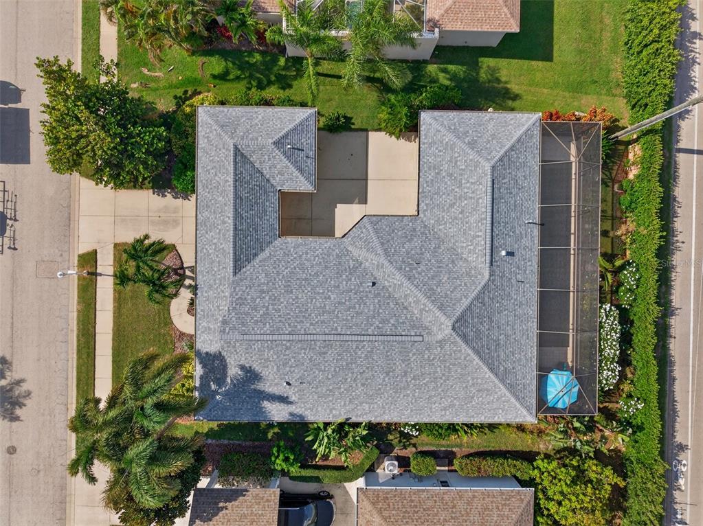 An aerial view shows a house with a gray shingled roof and a screened-in patio — 171 AMERICAS CUP BOULEVARD, BRADENTON, FL