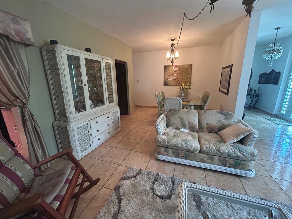 A living and dining area features tile floors, a wicker hutch, and a floral sofa — 545 SECTOR TORO, COAMO, PR