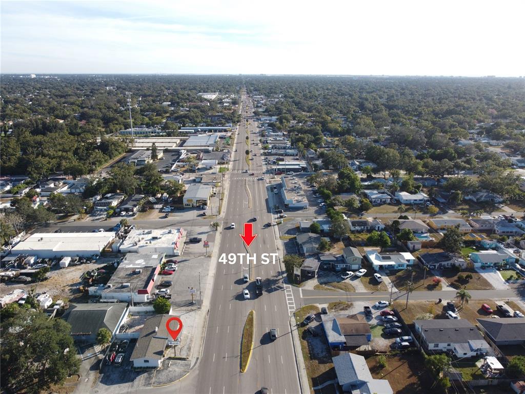 An aerial view shows a multi-lane road with a median and surrounding commercial and residential buildings — 4795 49TH STREET N, ST PETERSBURG, FL