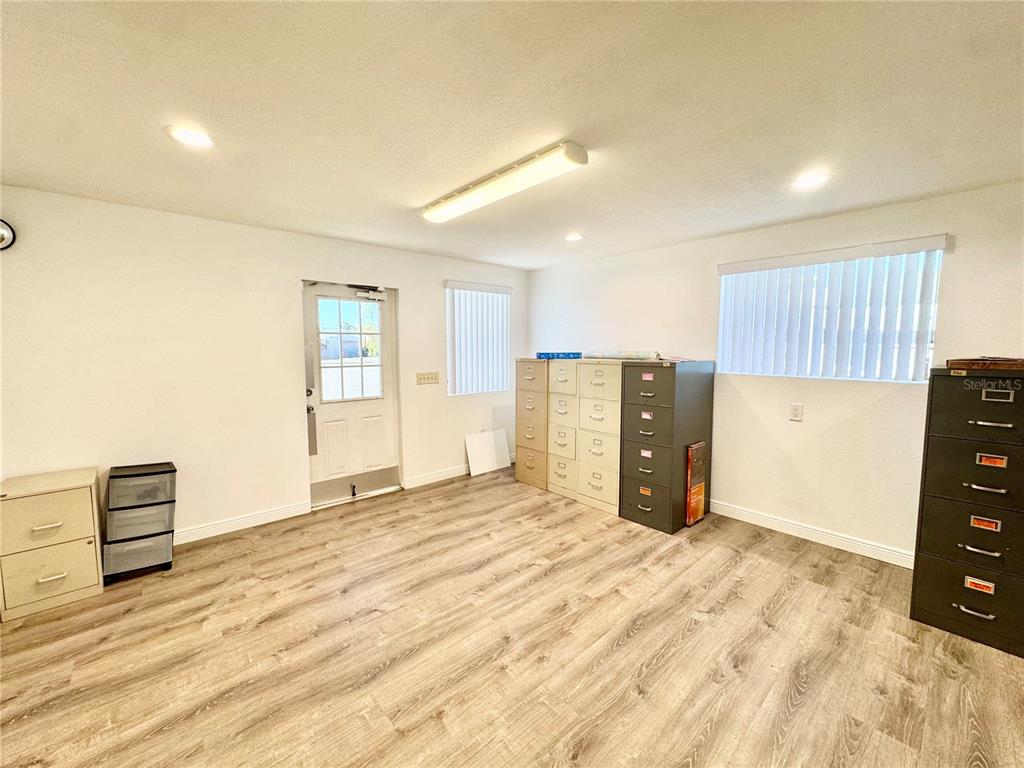 An office room with wood-look flooring, white walls, a door, and multiple metal filing cabinets — 4795 49TH STREET N, ST PETERSBURG, FL