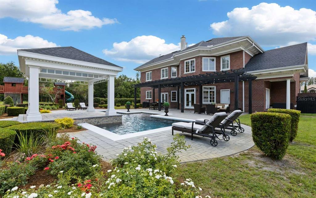 A brick house with a pool, a covered pavilion, and a pergola in the backyard — 537 SW WINDSOR DRIVE, LAKE CITY, FL