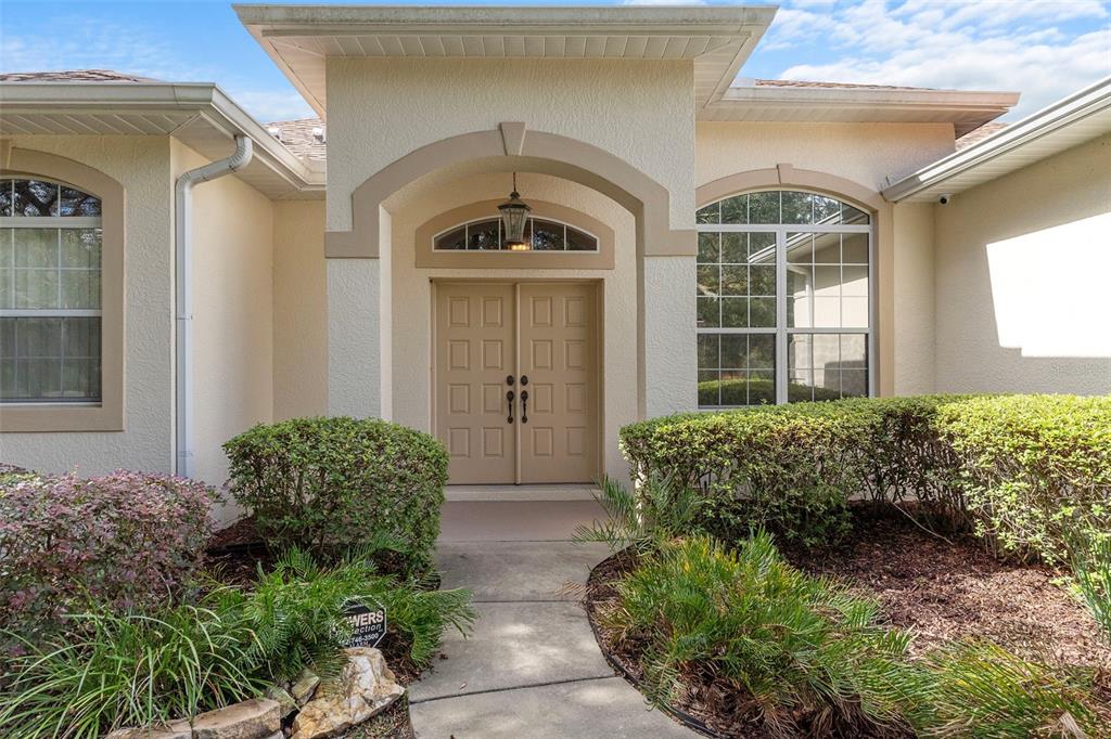 The front exterior of a house features a concrete walkway leading to double entry doors — 4202 N PONY DRIVE, BEVERLY HILLS, FL