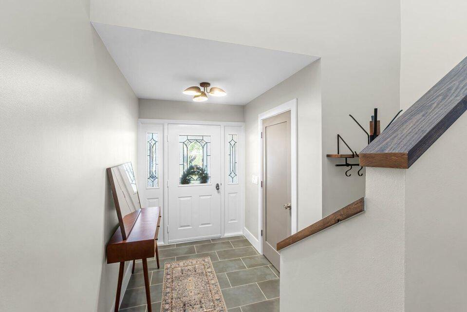 An entryway features a white front door, tile flooring, a console table, and a staircase — 17138 Waterbend Drive # 217, Jupiter FL 33477, JUPITER, FL
