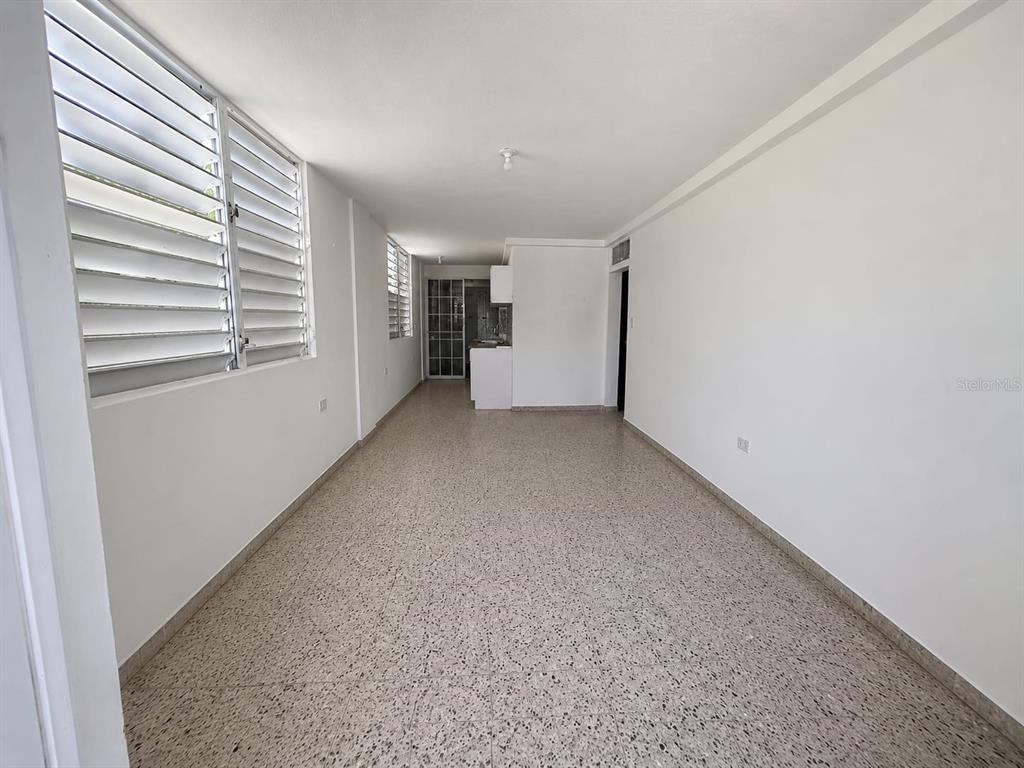 An empty room with white walls, terrazzo flooring, and louvered windows — A1A CALLE A  URB. LOS ANGELES, YABUCOA, PR