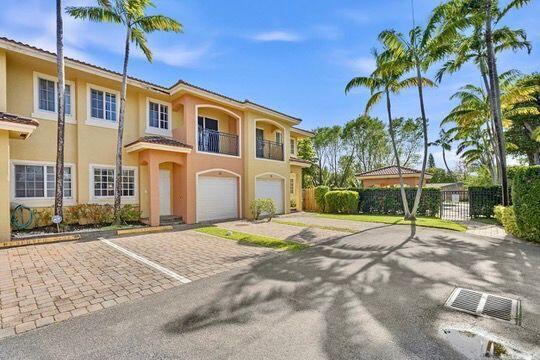 A multi-story tan townhouse exterior with palm trees, a paved driveway, and a parking area — 330 SW 2nd Avenue # 14, Hallandale Beach FL 33009, HALLANDALE BEACH, FL