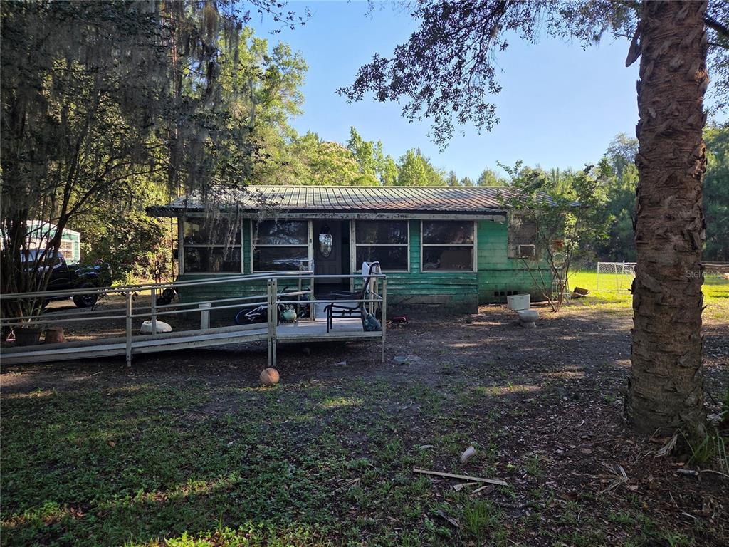 A green, single-story house with a metal roof and a metal wheelchair ramp — 9845 NW 160TH STREET, REDDICK, FL