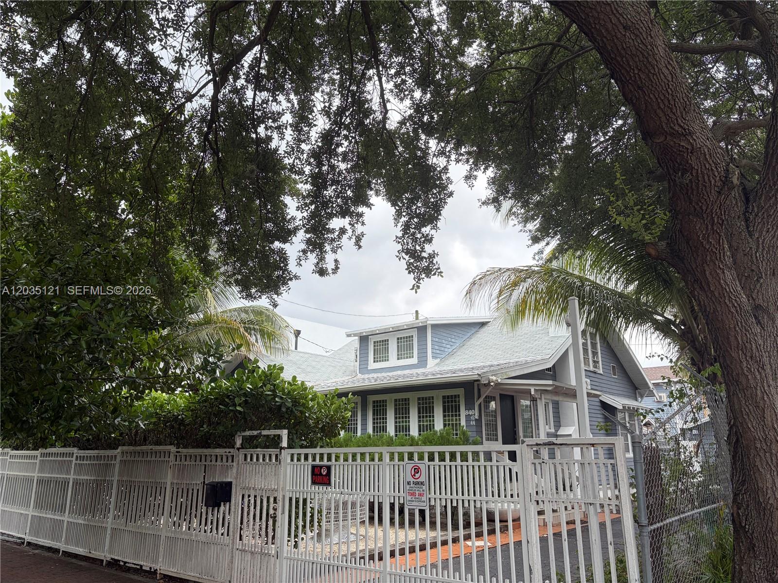 A blue house with a white roof sits behind a white metal fence — 840 SW 13th Ave, Miami FL 33135, MIAMI, FL