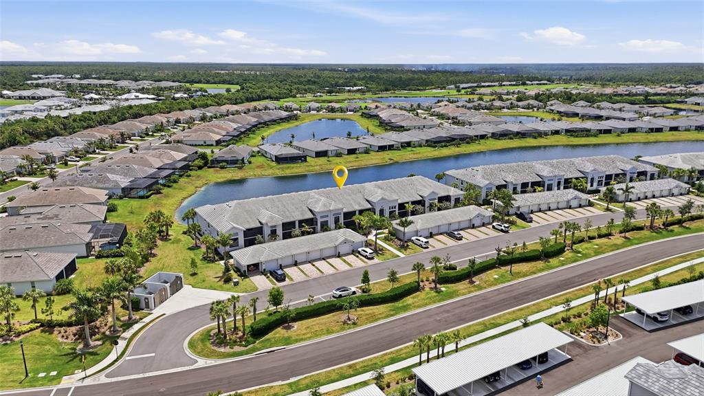 An aerial view shows a multi-unit residential building with a lake and parking structures — 14184 HERITAGE LANDING BOULEVARD UNIT 525, PUNTA GORDA, FL