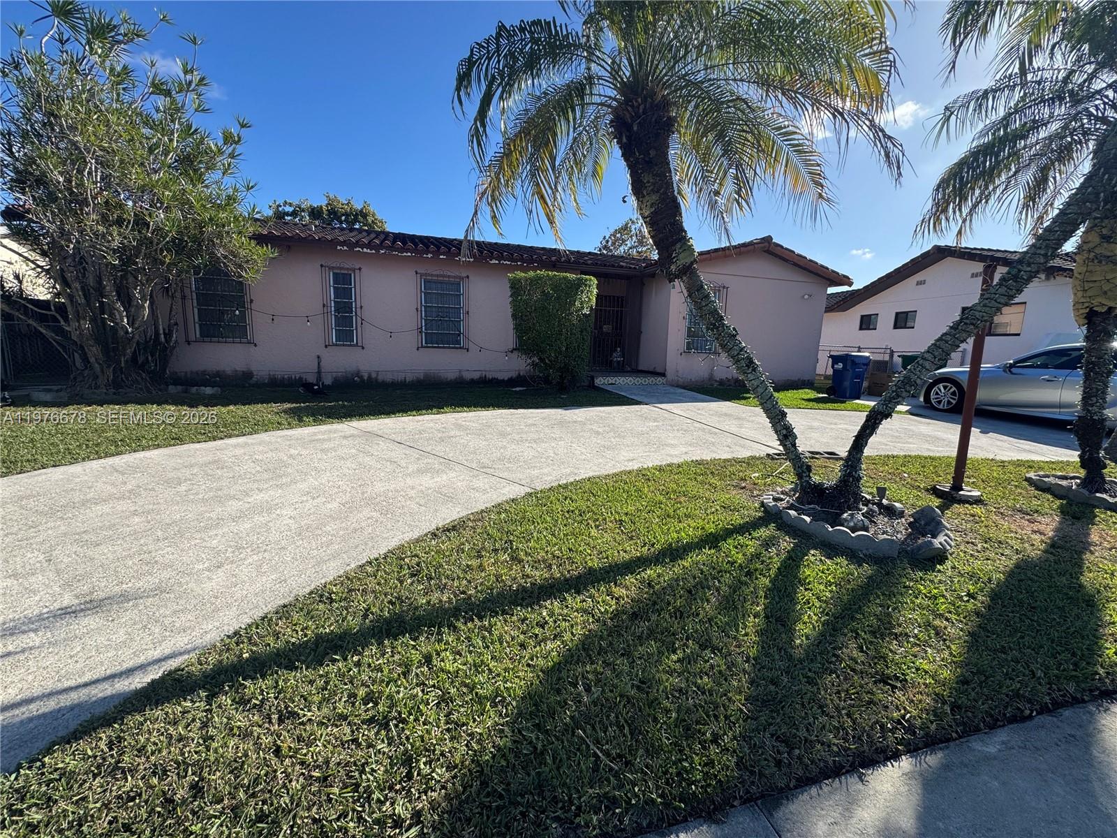 A single-story pink house with a tile roof and a curved concrete driveway — 10730 SW 66th Dr, Miami FL 33173, MIAMI, FL