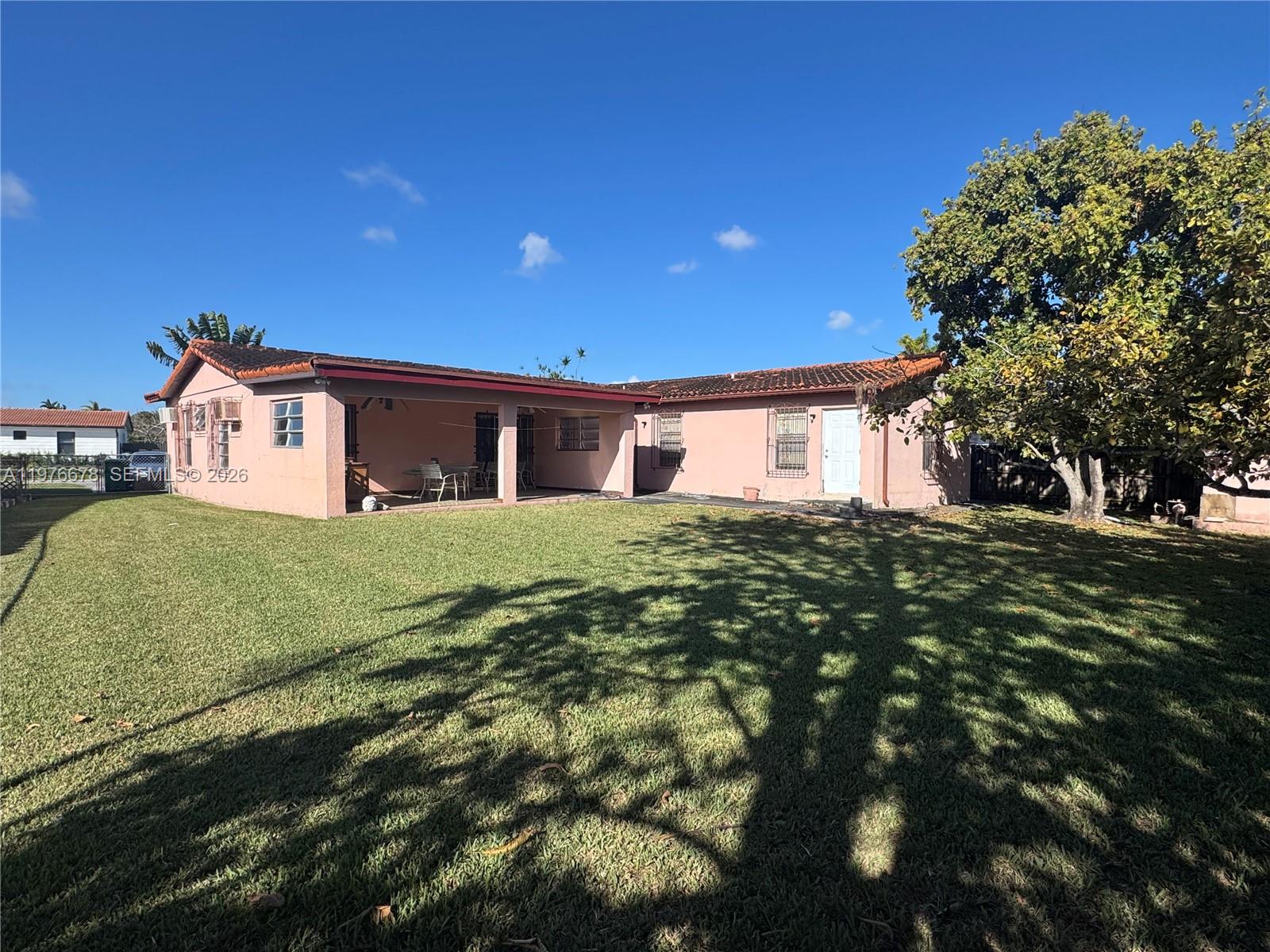 A pink, single-story house with a covered patio and a large tree in the yard — 10730 SW 66th Dr, Miami FL 33173, MIAMI, FL